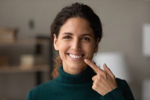 smiling woman pointing to smile